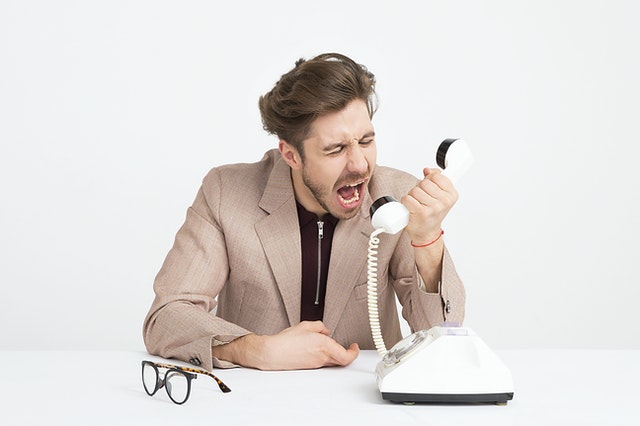 man wearing brown suit jacket mocking on white telephone 1587014 1